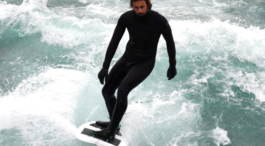 Man in a wetsuit surfing on a rough sea