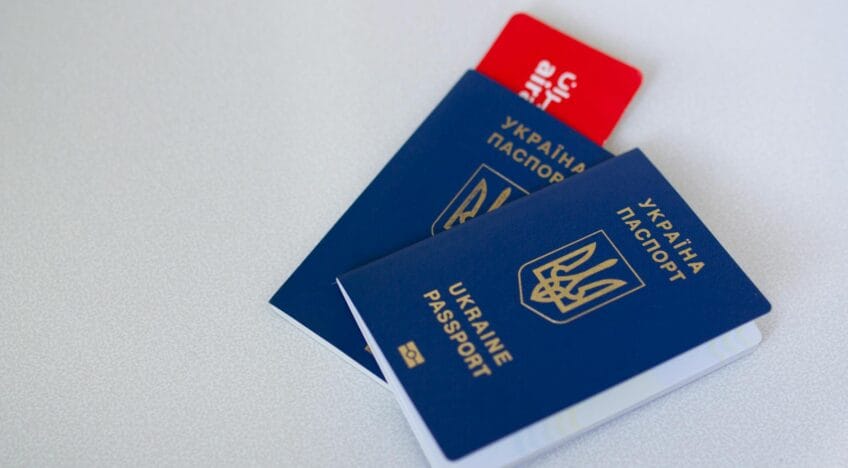 Close-up of Ukrainian passports and travel card on a light surface with ample copy space.