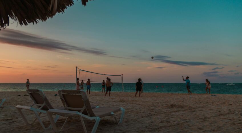 Beachgoers enjoying a game of volleyball at sunset in Punta Cana, Dominican Republic.
