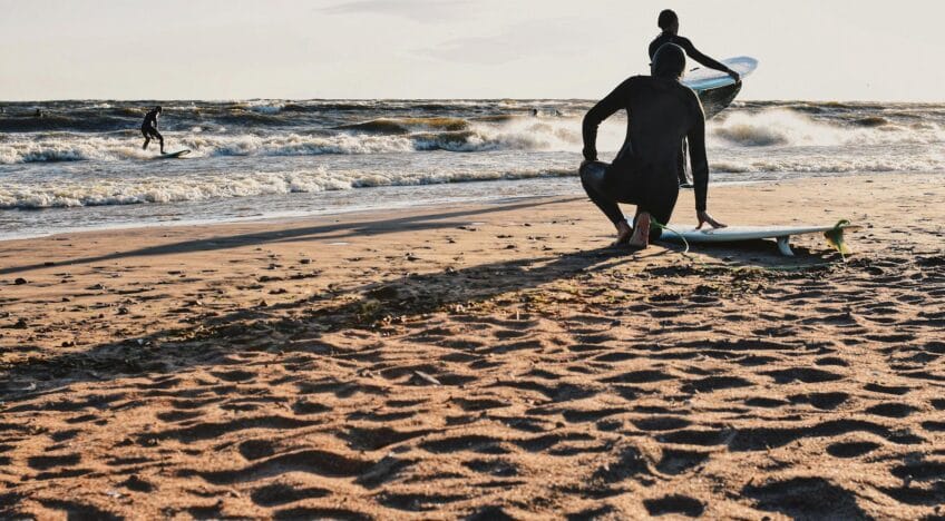 Surfers getting ready on a Saint Petersburg beach, enjoying waves and sunset vibes.