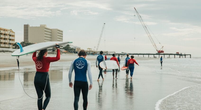 Pessoas Em Uma Praia Com Um Barco Branco E Vermelho A Distancia AbsCbHcWMco